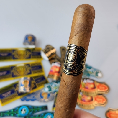 अच्छी कीमत उच्च गुणवत्ता वाले निजी ब्रांडिंग वाटरप्रूफ सिगार लेबल स्टिकर के साथ स्पॉट यूवी और गोल्ड फोइल एम्बोस्ड प्रिंटिंग के साथ प्रीमियम कस्टम विनाइल मुद्रित सिगार रिंग ऑनलाइन